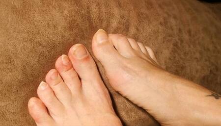 Pointy long natural toenails scratching fabric and hand's skin