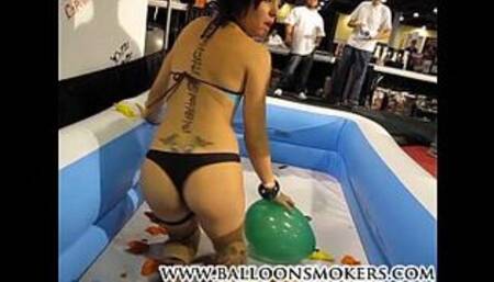 Teen pops balloons inside pool at Exxxotica