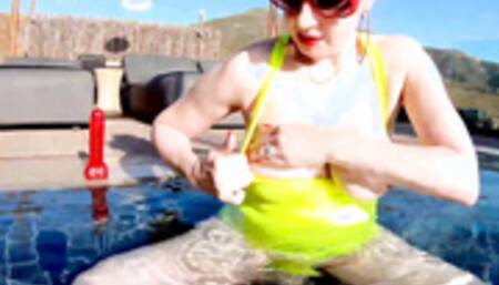 Red XXX fucks her pussy with a toy in the pool