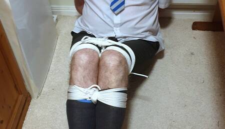 Tightly bound and gagged man in adult school uniform kept in room