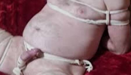 Naked man tied in futomomo bondage by woman