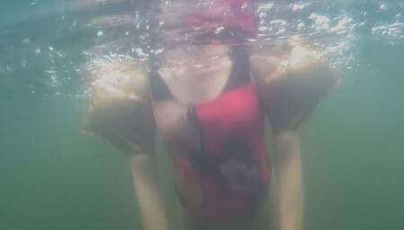 Alla swims underwater in a diving mask and wears gold inflatable armbands for safety!!!