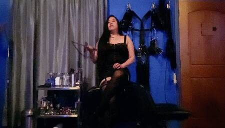 Domina Mara in a Leather Skirt, Garters, Stockings, and a Whip