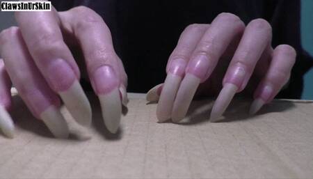 nails aggressively scratching cardboard