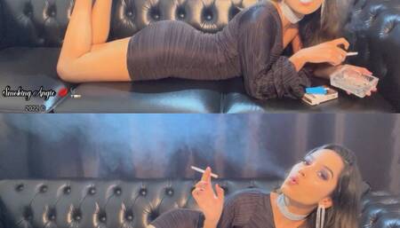 Smoking a long cigarette in my black minidress reclining in the couch