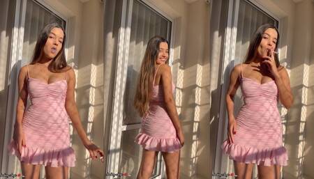 Angie smoking in the balcony in a sunny day wearing a beautiful tight pink minidress