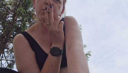 Hot italian milf smoking in a public garden avi