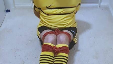 Footballer in yellow and black kit struggling to get out of tight bondage 1