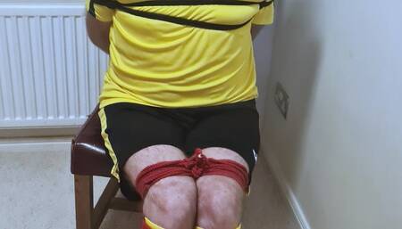 Footballer in yellow and black kit struggling to get out of tight bondage 2