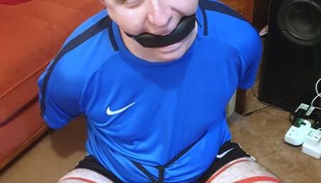 Man in football kit bound and gagged cross-legged by woman 2
