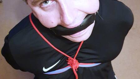 Footballer bound and gagged in black and red kit