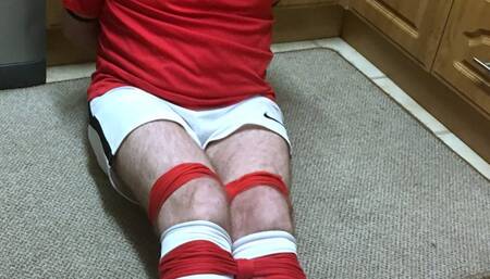 Footballer bound and gagged tight and struggling in kitchen
