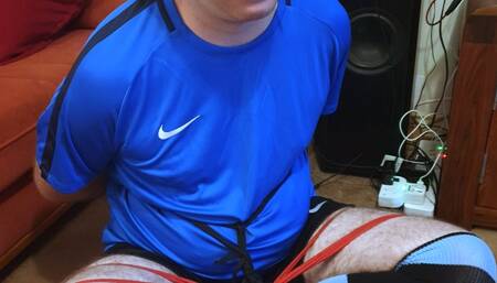 Man in football kit bound and gagged cross-legged by woman 4