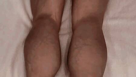 Iron Ivy lying on a mattress flexing her leg muscles