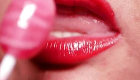 Sensual licking of a red lollipop with a gentle tongue