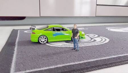 Giant plays with tiny man and car