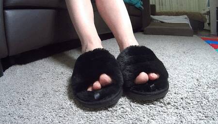 Toe wiggling in plush black slippers (T)