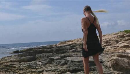 outdoor public toilet and flashing in see through dress on rocky sea shore