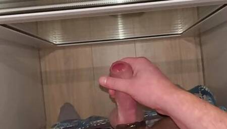 A young guy masturbates his dick and cums in a public place filming himself on camera close-up.