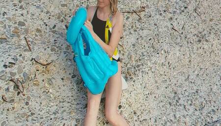 Alla deflates a blue inflatable vest on the beach and folds it compactly!!!