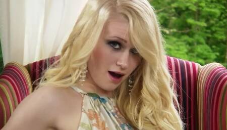 A busty blonde girl is taking off her long dress to shake her ass
