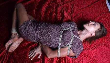 Delta: barefoot girl, wearing a dress, hogtied with hemp rope, wiggles and rolls on the bed, and later is being tickled by camera man (HD MOV)