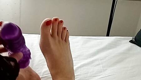 Milf tranny simulates a Footjob with a vibrator between her red painted toes