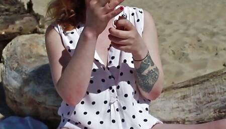 Girl wets a diaper on the beach and then smokes a cigarette