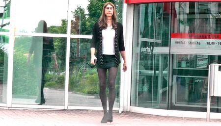 Crossdresser in short skirt, black stockings and high heels