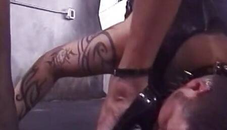 Slave dude in spiky leather collar sucks dominatrix's stilettos