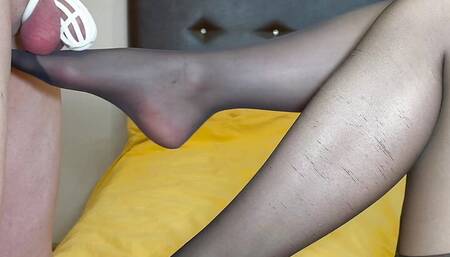 FootJob teasing cock in chastity cage