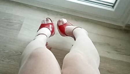 Milf tranny sits on a chair, speaks in her sexy voice, touches herself and shows off her slim legs and heels