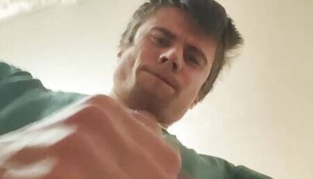 guy in a green T-shirt jerks off and cums on the phone
