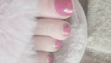 Pink fuzzy slippers and pink-red toes