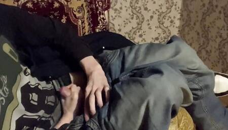 A boy in sneakers masturbates in the dark on an armchair