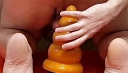 guy in a chastity cage stretches his ass with a huge plug