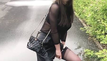 Sissy walks on the road after the rain in high heels