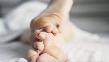 Callused feet relax in bed (4K)