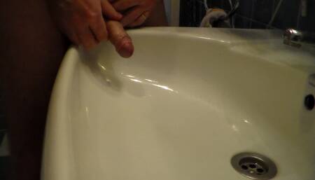 John is Peeing into the Bathroom Sink