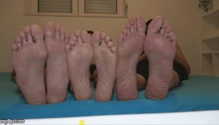 small foot of a man between two big woman feet