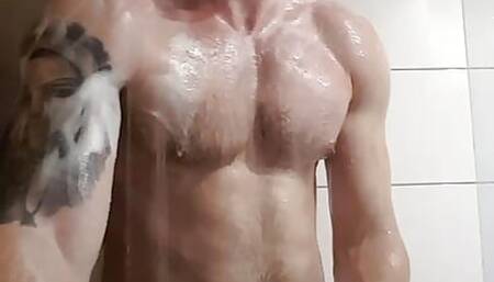 Muscular sexy fitness european guy with tattoo showing muscles