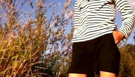 Cute sailor boy in short shorts is doing a striptease to show off his slim naked twink body outdoor