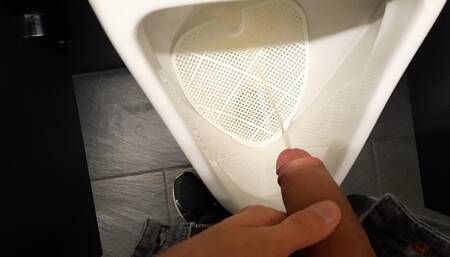Young boy pissing in public toilet