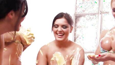 Watch these horny starlets wrestle and slide around on a tarp full of banana cream.