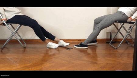 TWO GIRLS TIED UP IN CONVERSE SNEAKERS ARE STRUGGLING TO REACH A CELL PHONE ON THE FLOOR - MOV HD