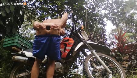 sexy young man poses with his motorcycle