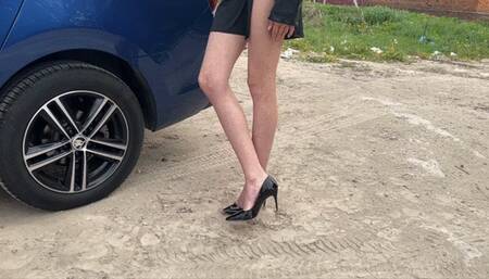 a girl in expensive patent leather high-heeled shoes walks through the trash, makes holes in the trash