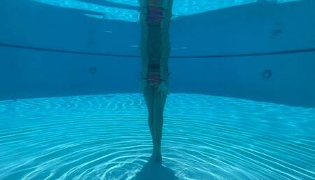 Wrist self-bondage in the resort pool in a rainbow bikini
