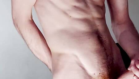 a guy with a beautiful body jerks off his dick and cums loudly