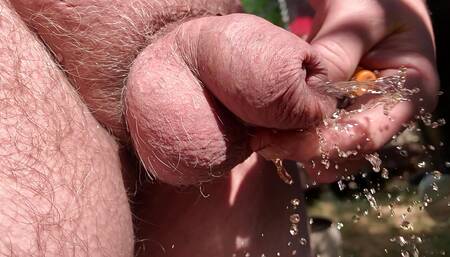 Uncut cock pissing through wet foreskin in the garden